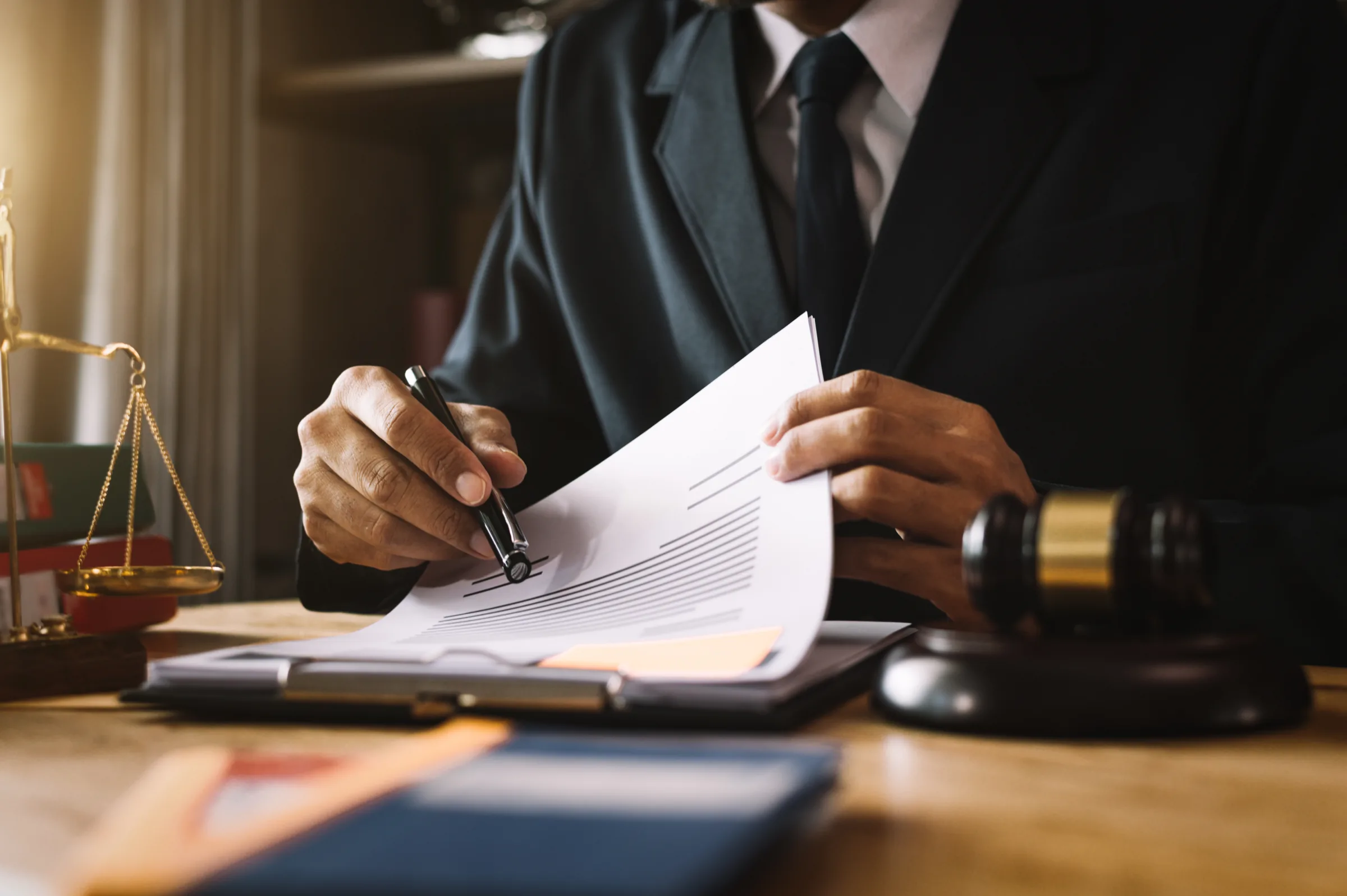 Avocat signant un acte à son bureau